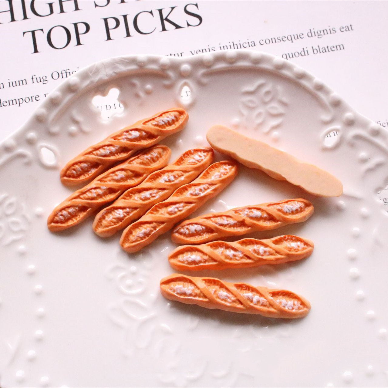 Jewelry Accessories Kit with miniature bread-shaped craft materials on a decorative white plate